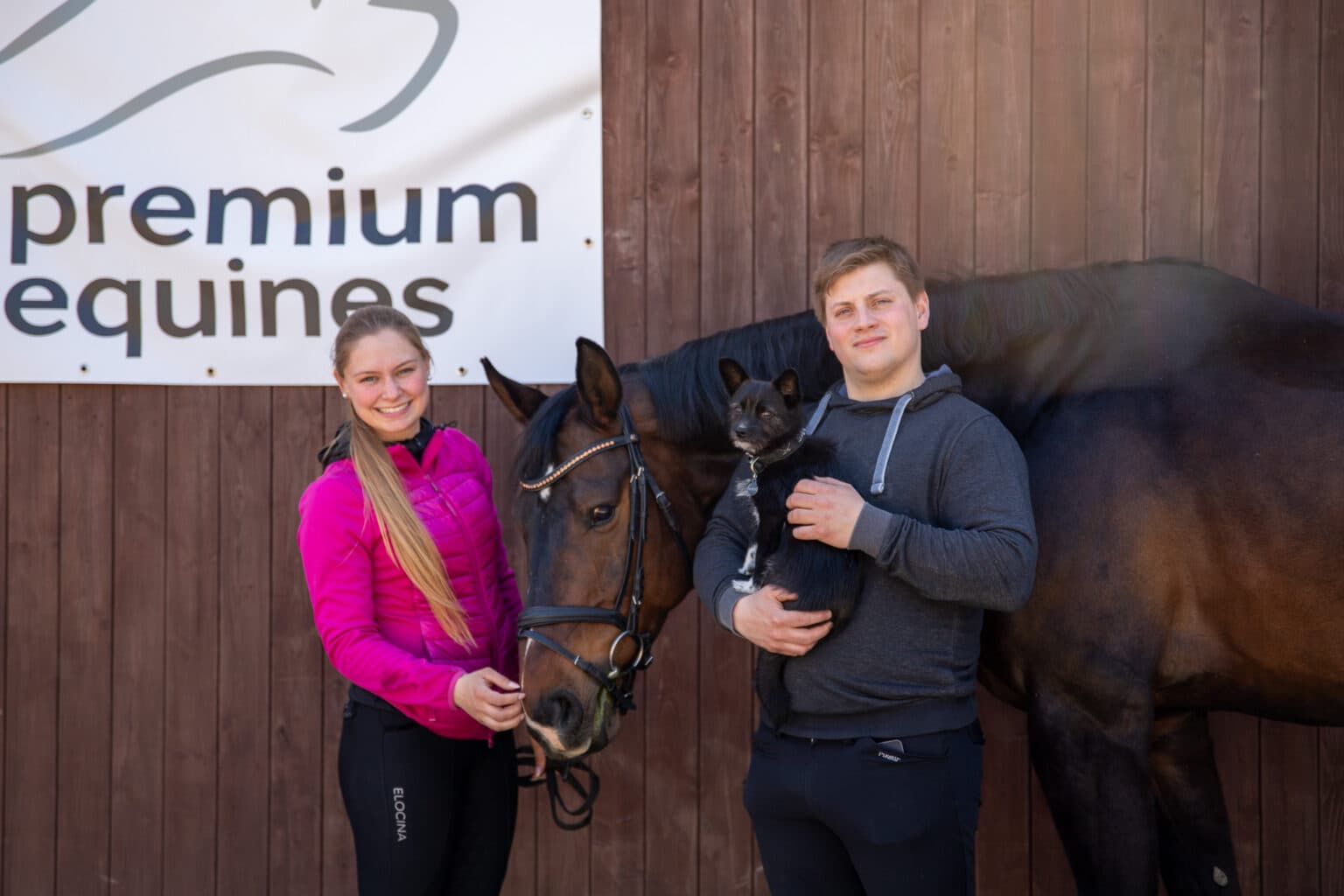 Zoe und Fabian mit Pferd und Hund vor dem Premium-Equines-Banner
